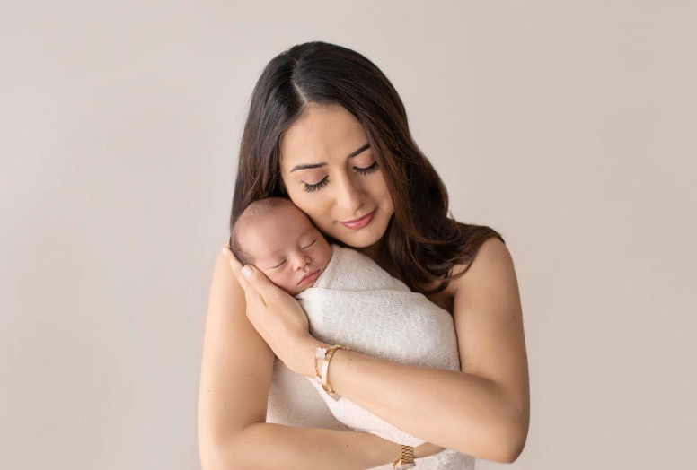 Madre sosteniendo a su bebé recién nacido dormido